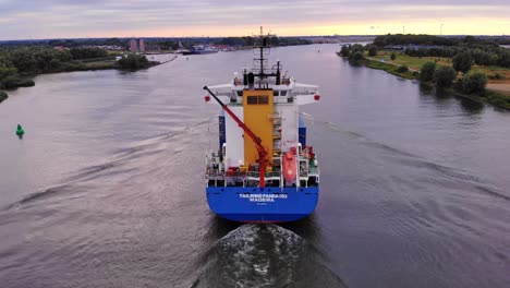 tracking shot from rear side of tailwind panda container ship cruising oude maas river, netherlands