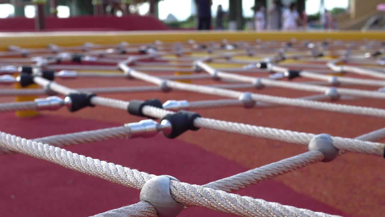 공원에서 등반 망: 어린이를 위한 게임 장비, 초점은 앞면, 배경은 부모와 자녀입니다.