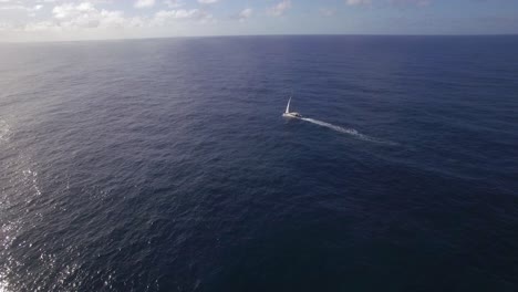 Vista-Aérea-Del-Yate-Blanco-En-El-Agua-Azul-Del-Océano-Vacío-Contra-El-Cielo-De-La-Isla-Mauricio