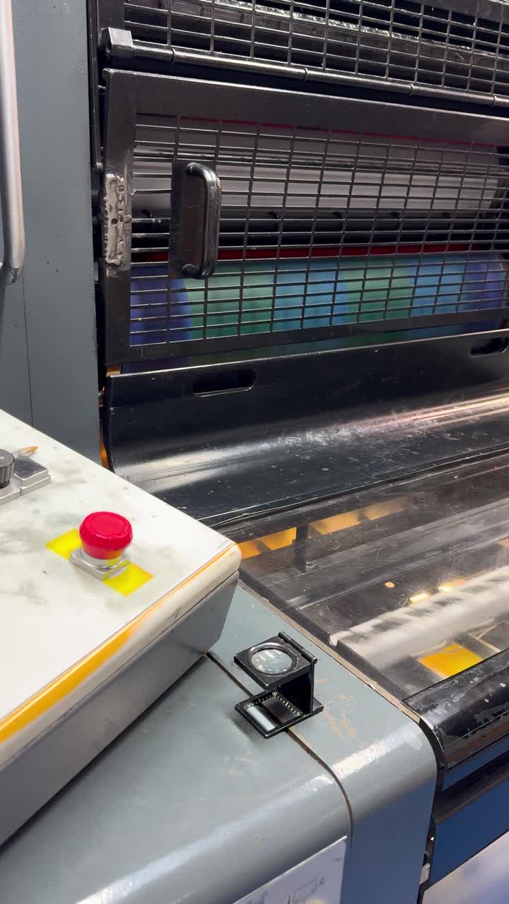 Industrial printing machine printing colorful flyers, close up