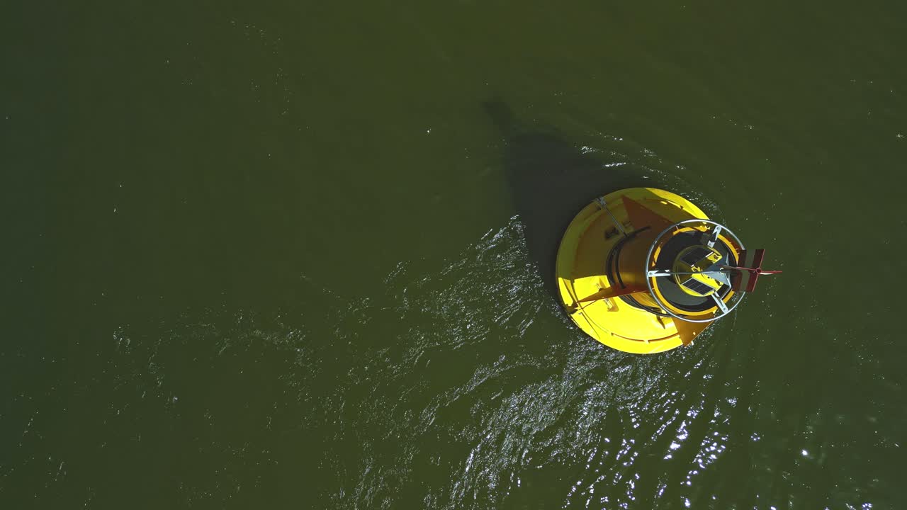 Yellow buoy bobbing back and forth in the river current seen from above