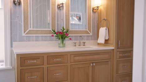 Primary-bathroom-sink-with-light-brown-cabinets,-white-countertop,-and-bright-finishes