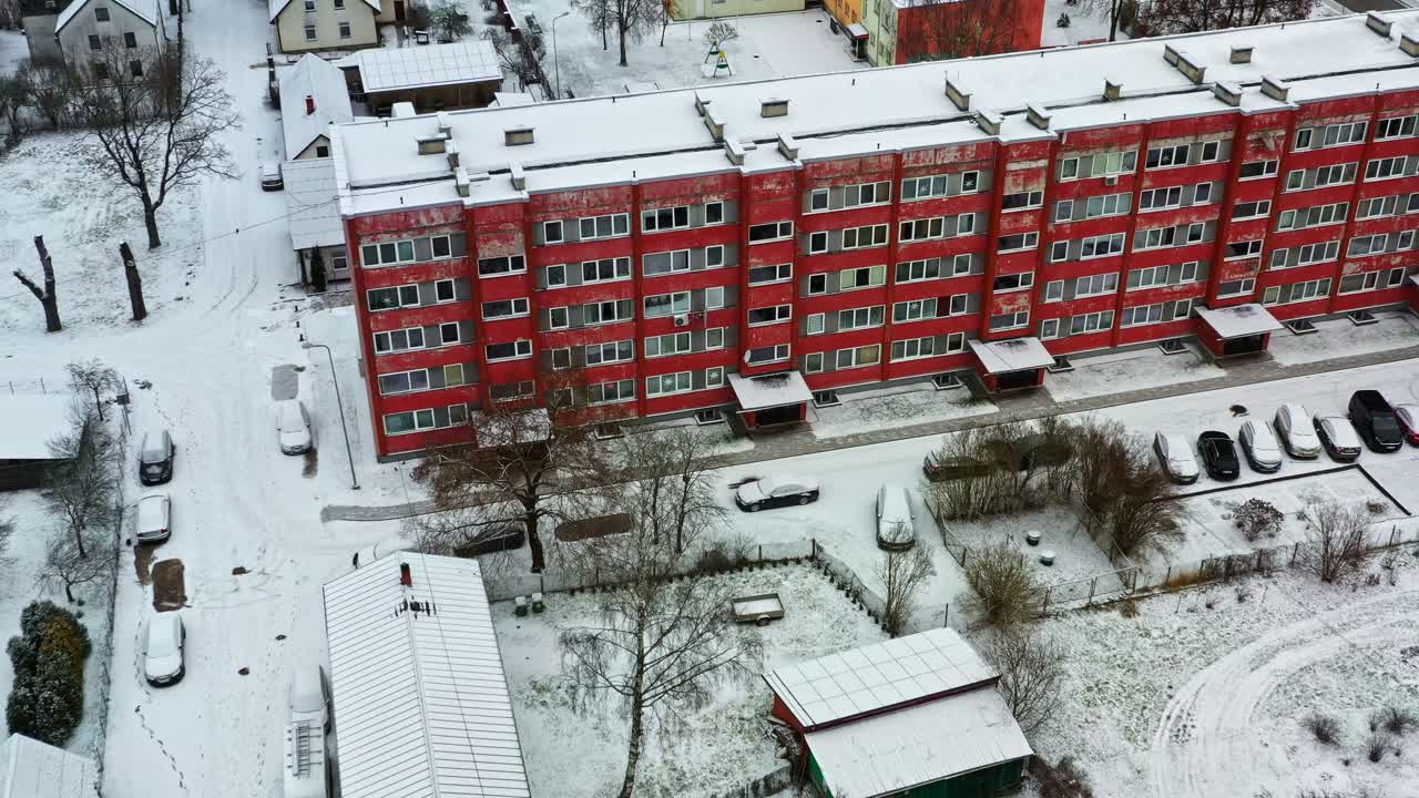 Asuinalueen rakennus, jonka katot ja maa ovat lumen peitossa talvella