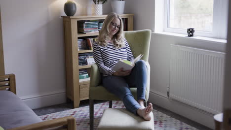 woman reading a book in a cozy living room