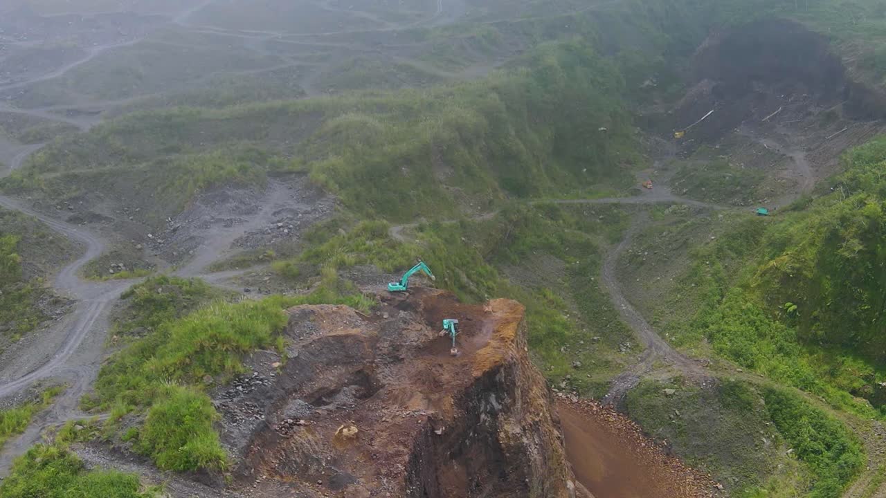 Two diggers excavating sand in open pit Merapi Mine in Magelang Indonesia aerial