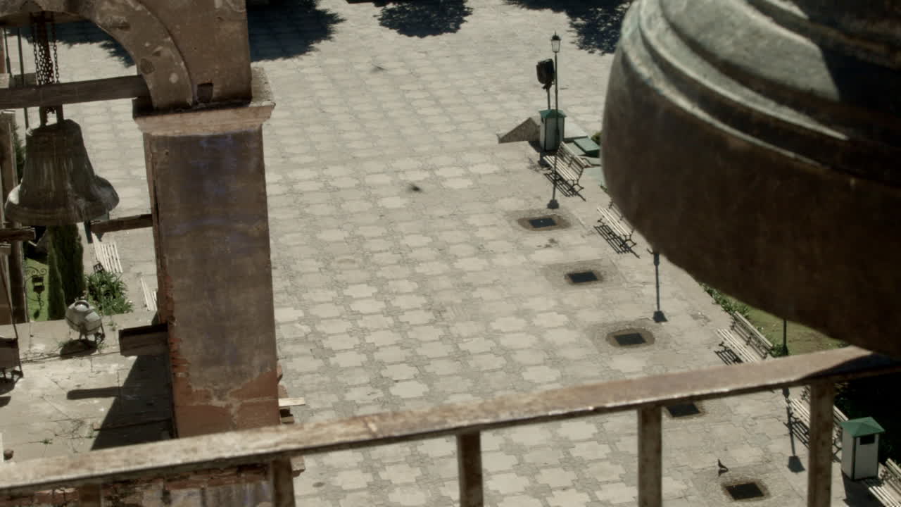 campanas de iglesia montadas en una torre alta en la plaza pública de un pequeño pueblo mexicano, que pueden ser escuchadas por la comunidad circundante