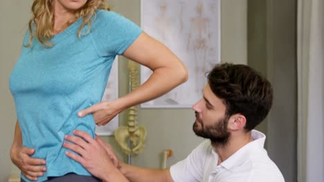 fisioterapeuta examinando la espalda de un paciente