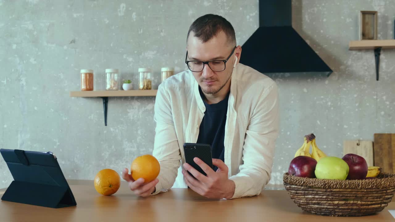 hombre enfocado de pie en el interior trabajando estudiando usando tableta escuchando música con cápsulas de aire en teléfono celular comunicación inalámbrica teléfono celular tecnología de internet tecnología de comunicación