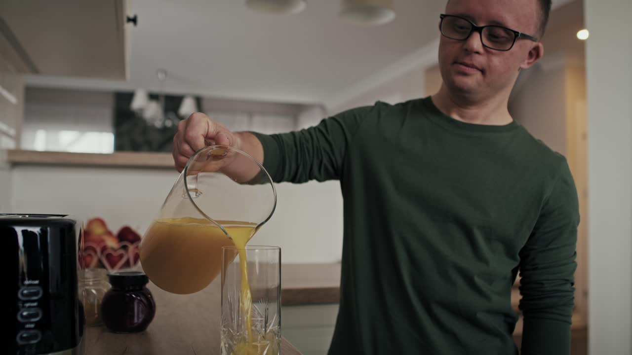 Hombre caucásico adulto con síndrome de Down preparando el desayuno