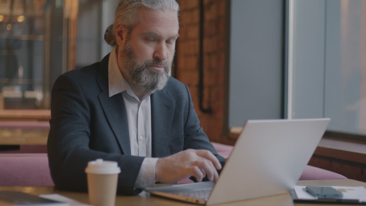 Businessman working on laptop in a cafe