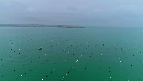 Fähre-Segelt-Durch-Schwimmende-Bojen-Im-Meer-In-Syrakus,-Italien