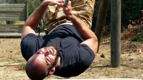 hombre cruzando la cuerda durante un curso de obstáculos
