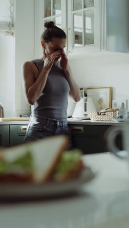 woman preparing breakfast in the kitchen, looking stressed.