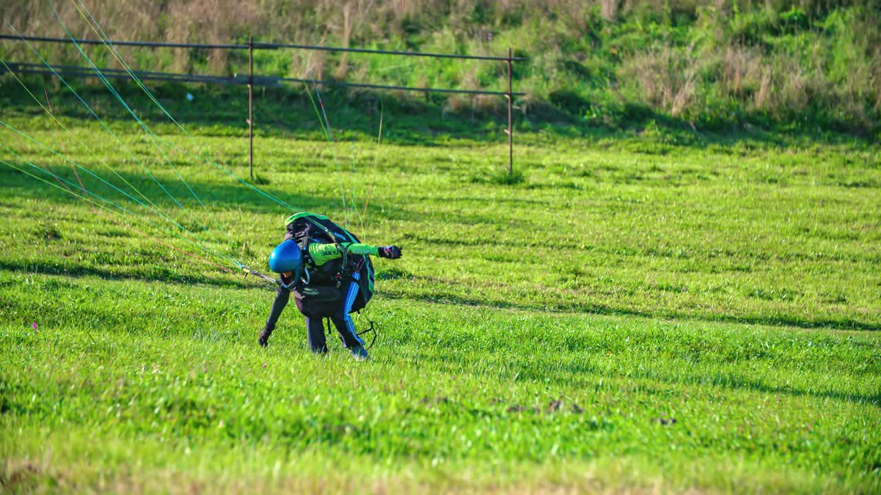 Extreme paraglider just lands on grass and quickly stands up