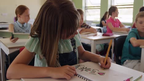 Niña-Dibujando-En-Su-Cuaderno-En-La-Clase