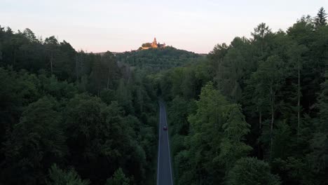 Aerial-images-above-a-street-between-the-woods-with-a-view-of-Braunfels-castle-in-germany