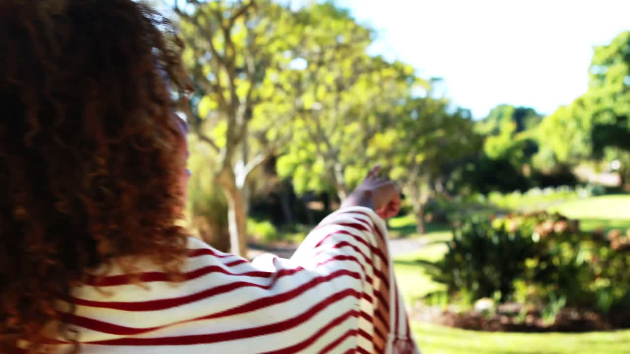 mujer señalando a la naturaleza