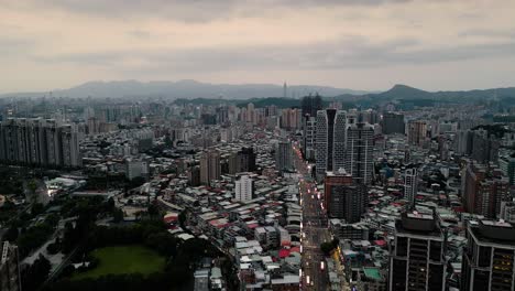 Vista-Aérea-Escénica-Sobre-El-Horizonte-De-La-Gran-Ciudad-De-Taipei-Desde-El-Distrito-De-Xindian-En-El-Crepúsculo-Atardecer-新店-Taiwán-Drone