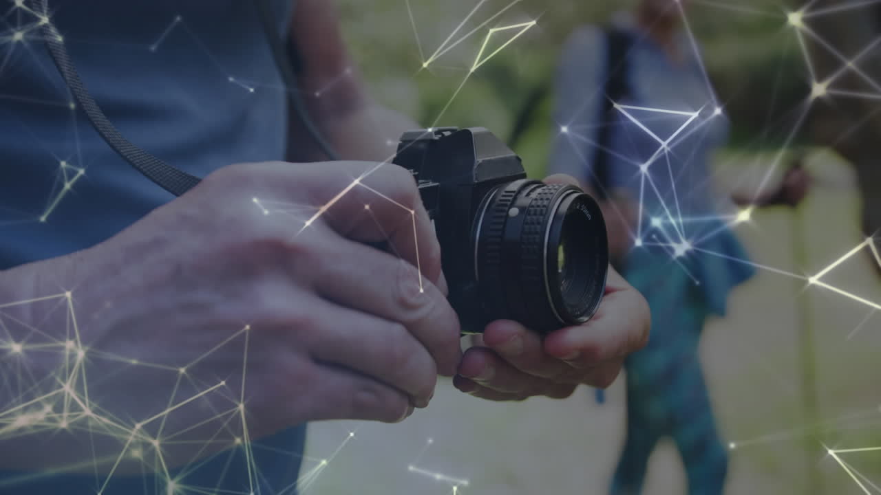 Network of connections over hands of caucasian senior man using digital camera in countryside