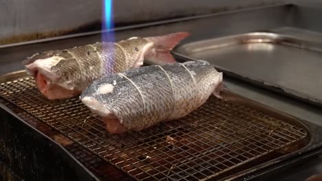 프로 셰프는 불꽃으로 긴 물고기를 사용하고, 연어 가득 찬 물고기 러드를 조리합니다.