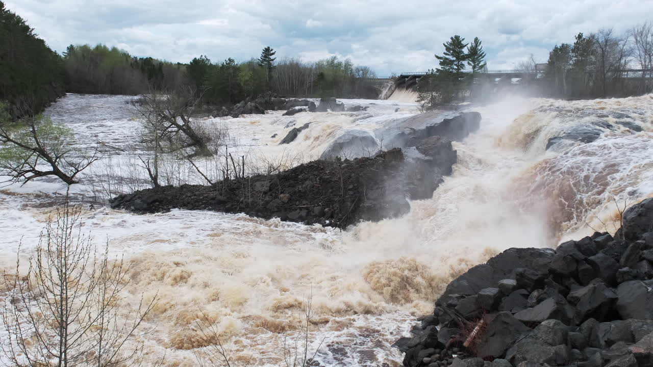 springtime flooding, rushing river water around a local dam