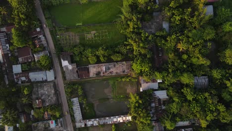 Observe-a-Bangladesh-slum-town-from-a-unique-perspective-with-this-top-down-footage,-showcasing-the-town's-vibrant-green-surroundings