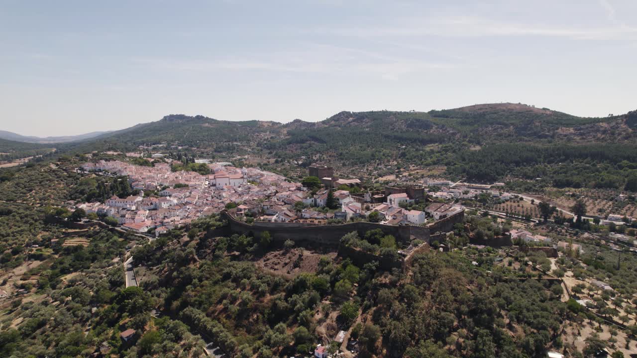 Vista aérea circular sobre un valle con un pueblo encaramado