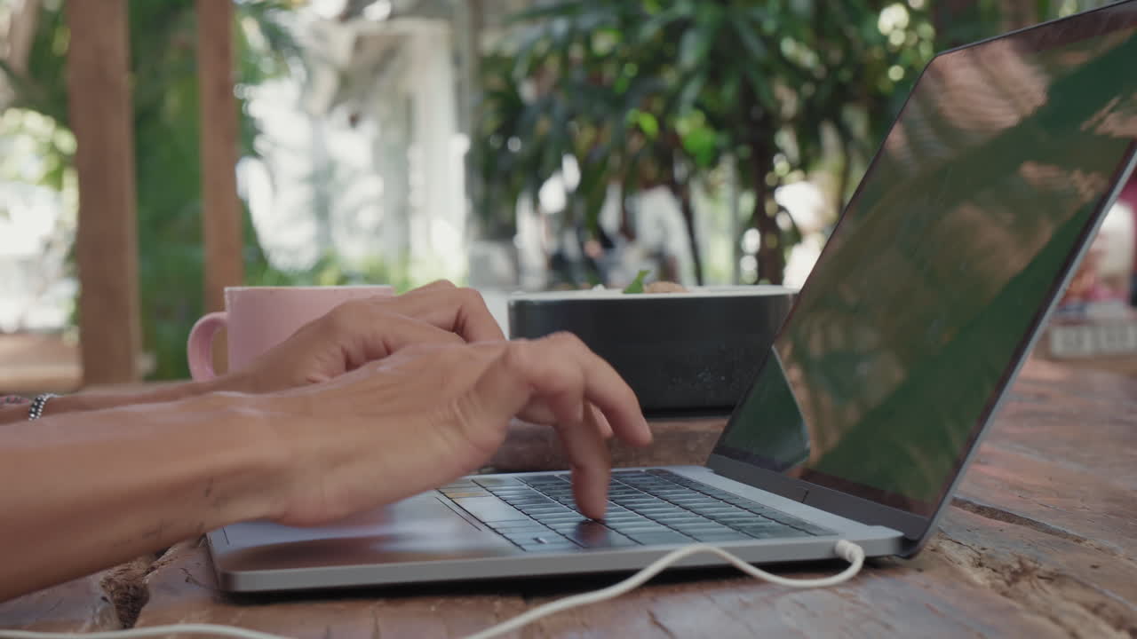 las manos escribiendo en la computadora portátil