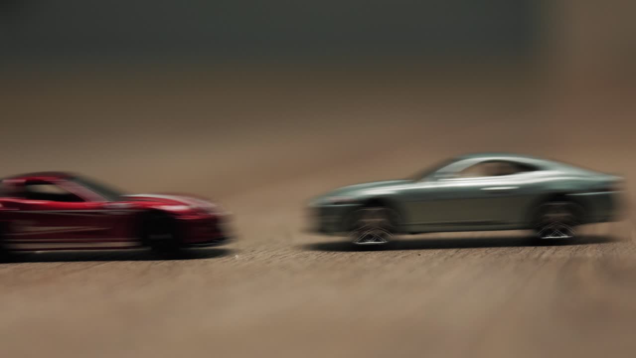Close-up of two toy cars colliding in slow motion on a wooden surface