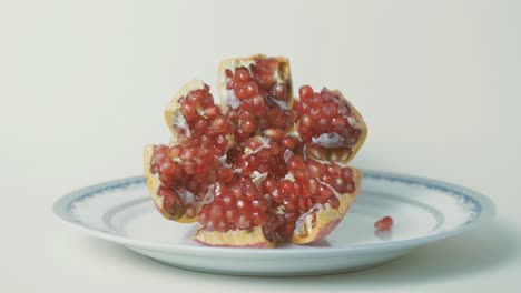 granada de aspecto delicioso colocada en un plato que muestra semillas de color rojo vibrante