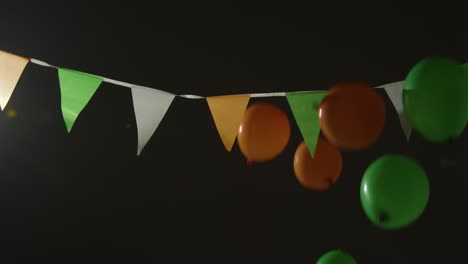 bunting and balloons in colours of irish national flag hung in studio to celebrate st patricks day