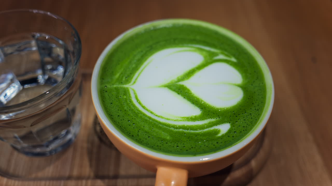Close up of a matcha latte on a wooden tray at a cafe