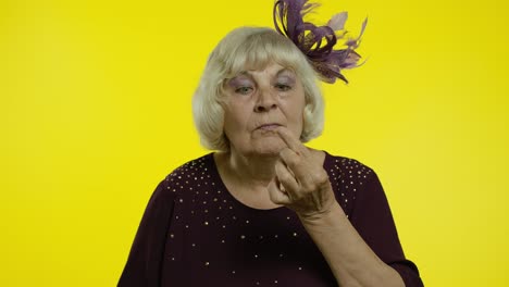 Funny-stupid-senior-old-woman-picking-nose-with-silly-expression,-removing-boogers,-bad-manners