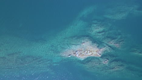 overhead 4k drone clip over a rock formation in the tropical blue waters of toroni in chalkidiki