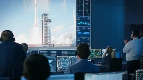 group of people in mission control center witness successful space rocket launch. flight control employees sit in front computer displays and monitor the crewed mission. team stand up and clap hands.