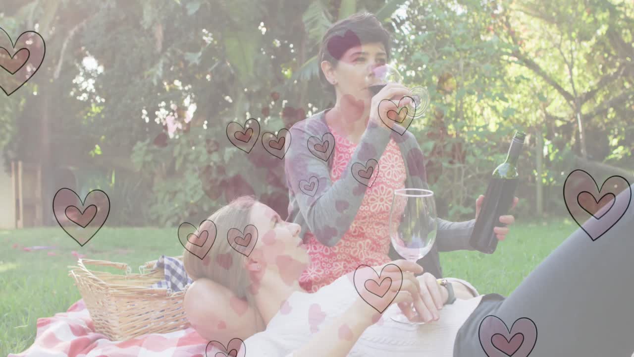 ハートエモジのアニメーション 幸せな白人女性カップルがワインを飲んでいます