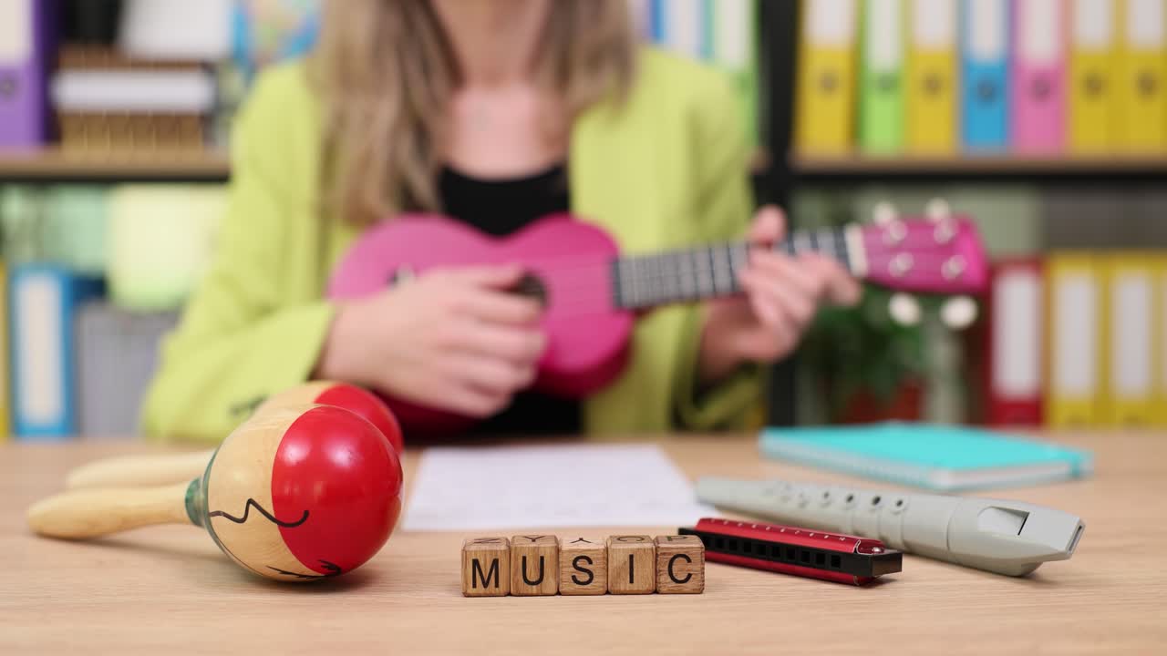 Woman Playing Ukulele with Musical Instruments on Desk