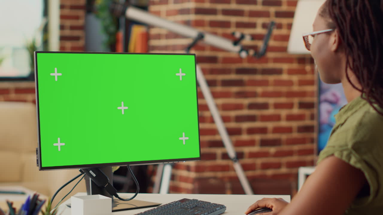Young businesswoman looking at greenscreen on computer