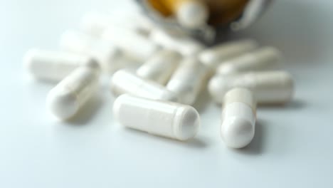 cápsulas blancas en una superficie blanca