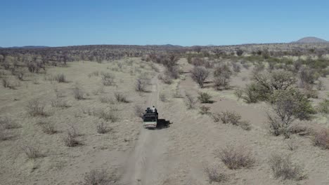 off road african safari vehicle dusty track aerial follow shot namibia