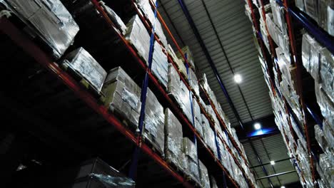 packages stacked high on shelving system of industrial warehouse; storage facility