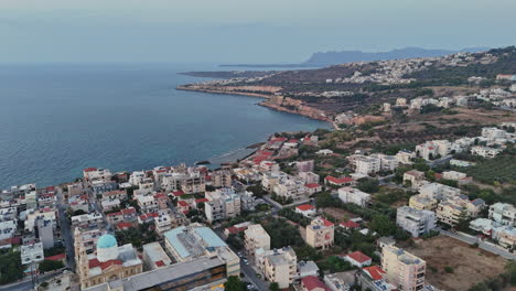 aerial view of coastal town with buildings and mountains at twilight