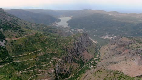 Toma-épica-Aérea-De-Caminos-Con-Curvas-O-Sinuosos-Y-Montañas-En-Lasithi