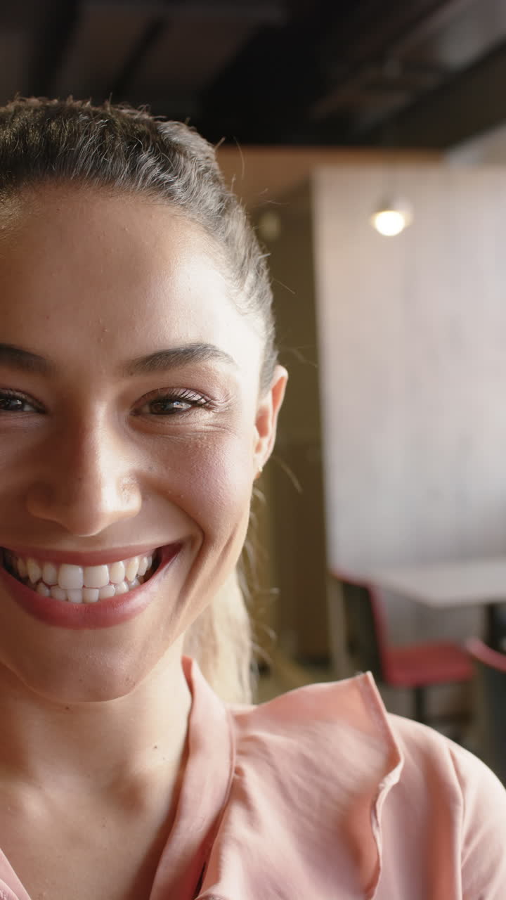 Vertical video of portrait of happy biracial businesswoman in slow motion