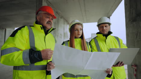 ingenieros civiles masculinos y femeninos están inspeccionando el plan de construcción del edificio arquitecto capataz e inspector