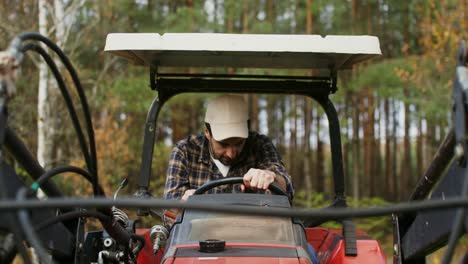 farmer driving tractor in forest