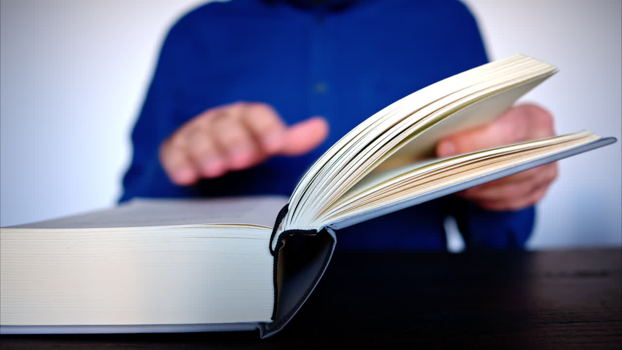Close-up of a man leafing through a big book
