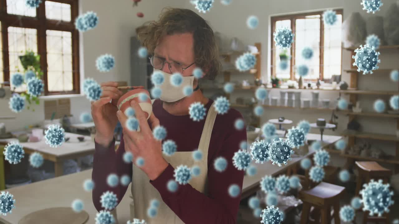 animación de las células de covid-19 sobre el hombre que trabaja en el estudio de cerámica con máscara facial