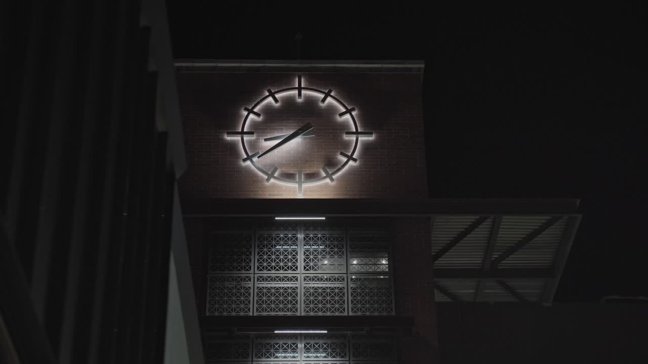 Large Glowing Analog Clock on Side of Downtown Brick Building