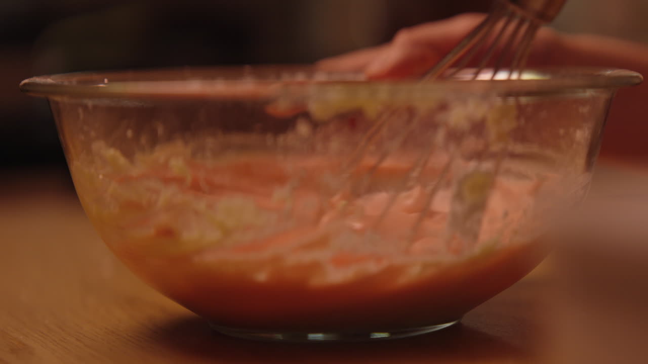 Close-up of a girl and mixing batter in a bowl